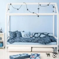 Bedhuis in kamer met blauw behang